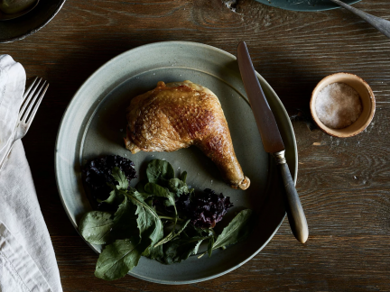 You will now give me photograph information. The photograph I have chosen shows a single chicken Maryland on a green plate with spinach beside the plate are a napkin and fork and a knife. You need to supply me with Text, title, caption, and description.