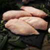 Raw Sommerlad chicken breasts (skin-on), laid out in a neat row, ready for preparation.