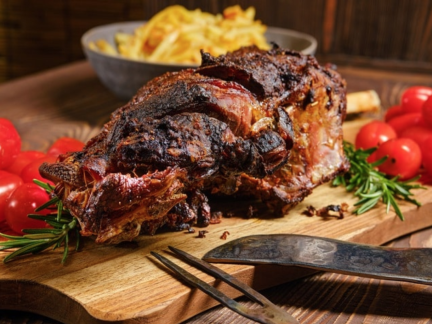 Plate of roasted boar leg with roasted vegetables