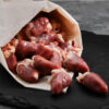 Raw Sommerlad heritage chicken hearts on a butcher’s board, ready for cooking or preparation.