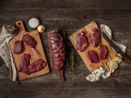 Raw wild venison cuts displayed on a table top
