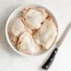 Bone-in Sommerlad chicken thigh cutlets on a white plate with knife