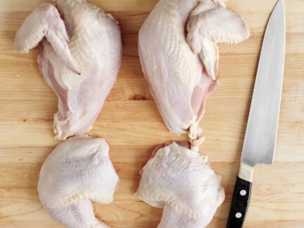 Quartered Sommerlad heritage chicken on a wooden board, ready to cook. Slow-grown, pasture-raised poultry from ethical Australian farmers.