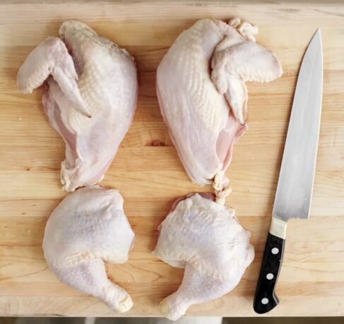 Quartered Sommerlad heritage chicken on a wooden board, ready to cook. Slow-grown, pasture-raised poultry from ethical Australian farmers.