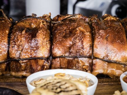 Whole roasted Wuuluman pork porchetta fresh from the oven, with crisp golden skin, made from regenerative pastured heritage pork.